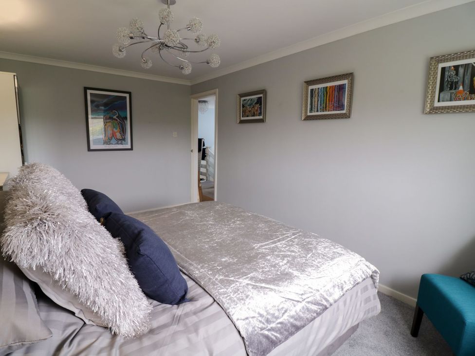 A bedroom with a bed and artwork at Gwelfor in Cemaes Bay