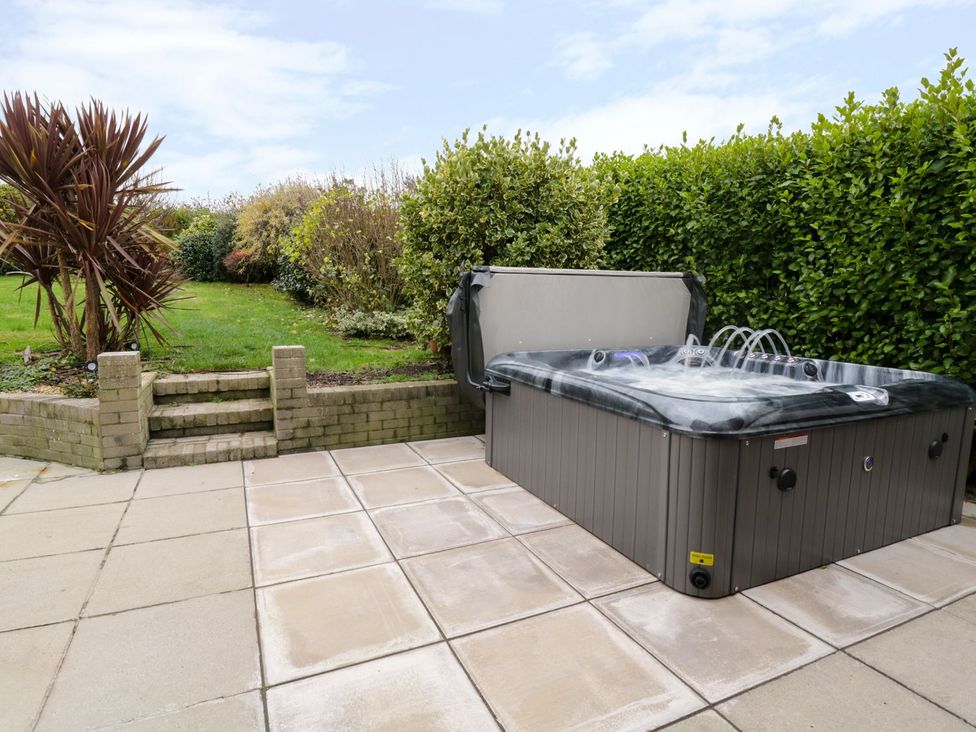 A garden with a hot tub and steps at Gwelfor in Cemaes Bay