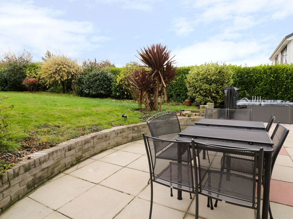 A garden with a dining table and chairs at Gwelfor in Cemaes Bay