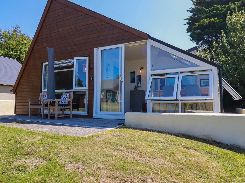 An outdoor view of a wooden cabin with patio furniture at Coombe Lodge No 9 in Bude