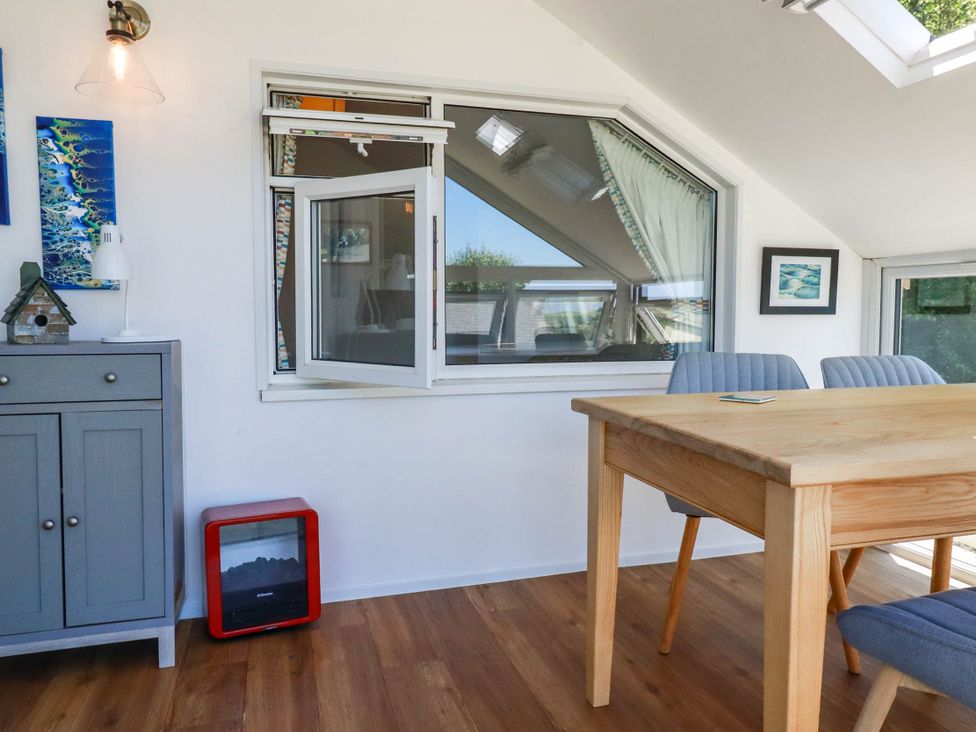 A dining room with a table and chairs at Coombe Lodge No 9 in Bude