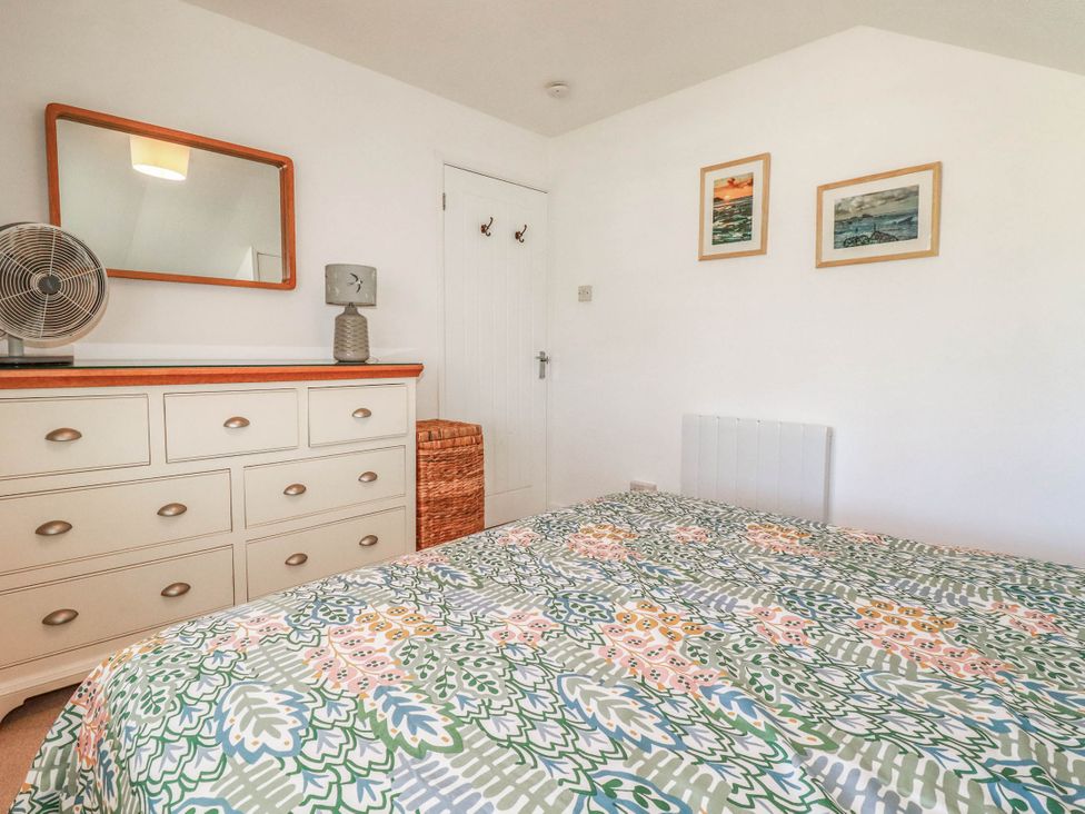 A bedroom with a bed and dresser at Coombe Lodge No 9 Bude