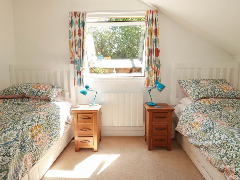 A bedroom with two twin beds and a window at Coombe Lodge No 9 Bude