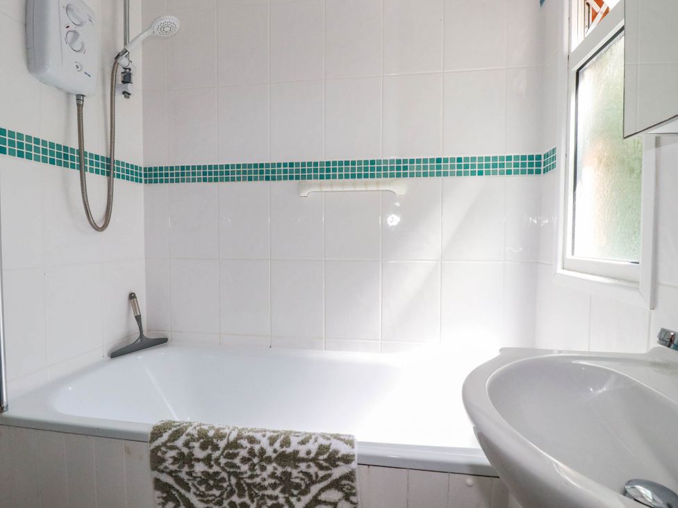 A bathroom with a bathtub and shower at Coombe Lodge No 9 Bude