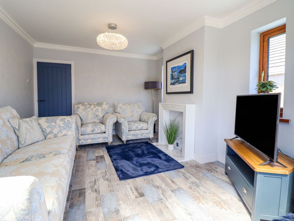 A living room with sofas and a television at Trefin Cemaes Bay
