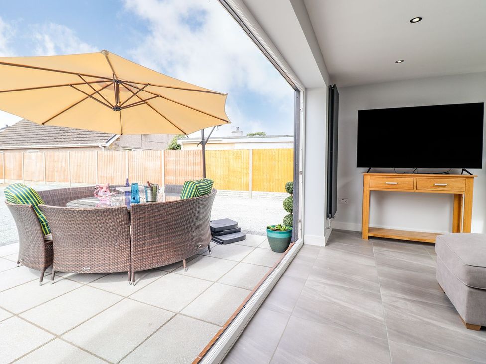 A living room with a view to an outdoor seating area at Trefin in Cemaes Bay