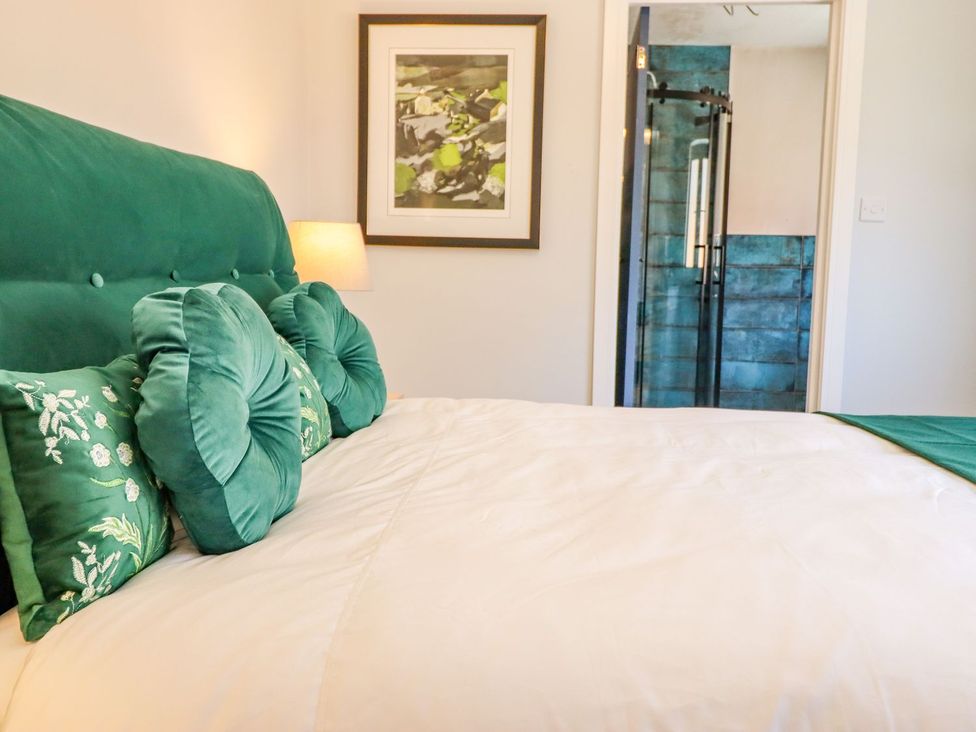A bedroom with a bed and shower stall at Trefin in Cemaes Bay