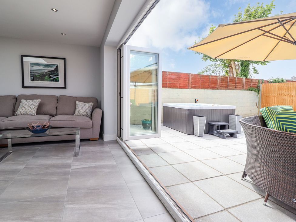 A living room with a sofa and hot tub at Trefin Cemaes Bay