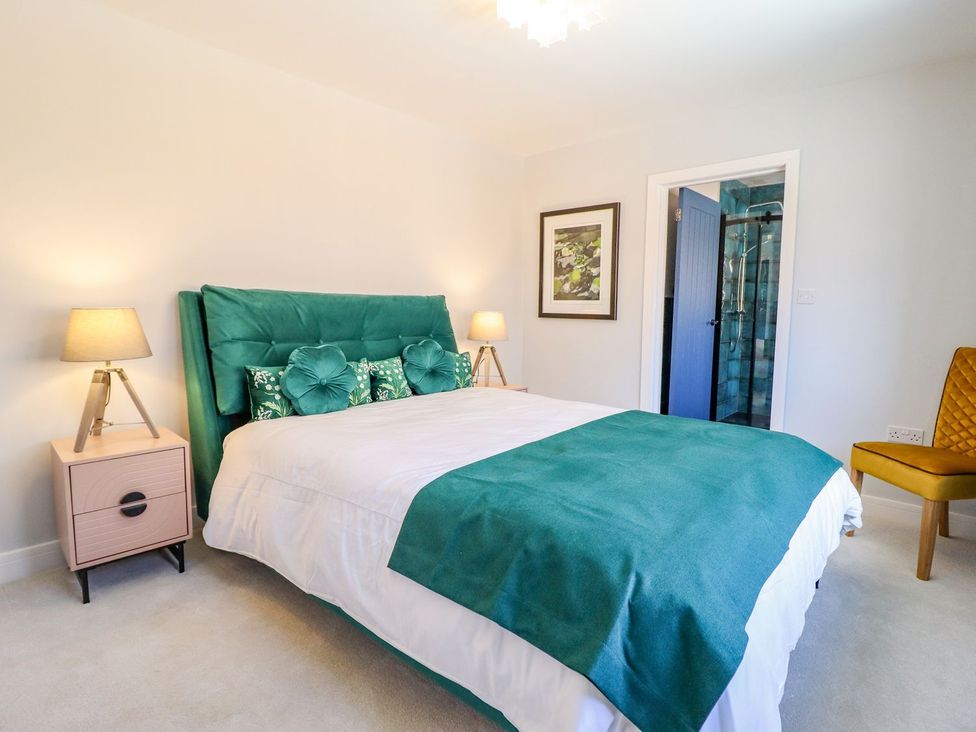 A bedroom with a bed and a bedside table at Trefin in Cemaes Bay