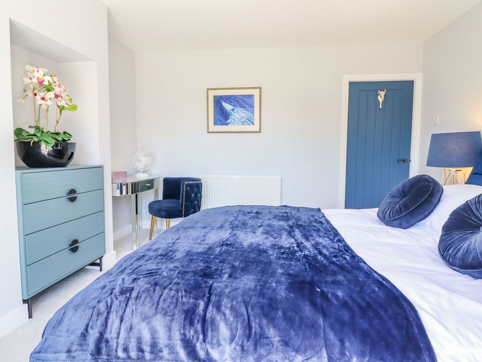 A bedroom with a bed and nightstand at Trefin Cemaes Bay