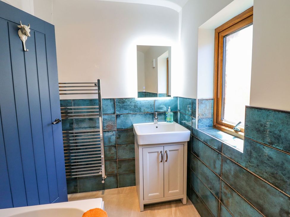 A bathroom with a sink and towel rail at Trefin in Cemaes Bay