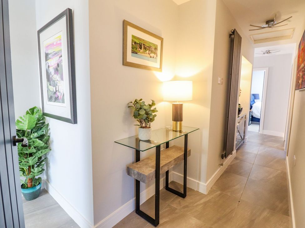 A hallway with a table and lamp at Trefin in Cemaes Bay