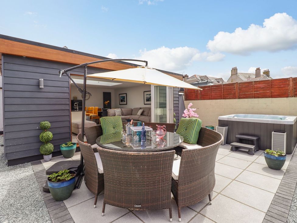 An outdoor area with a dining table and chairs at Trefin in Cemaes Bay
