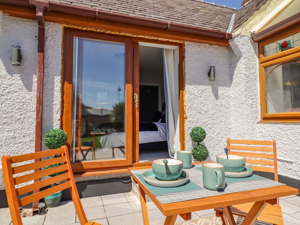 A table with cups and saucers on a patio at Trefin Cemaes Bay