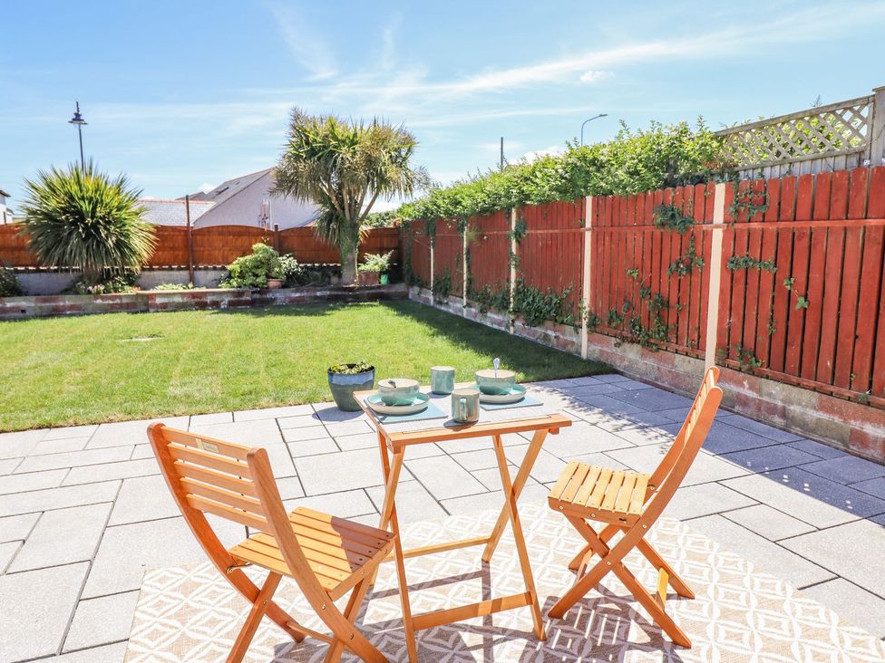 A garden with a table and chairs at Trefin in Cemaes Bay