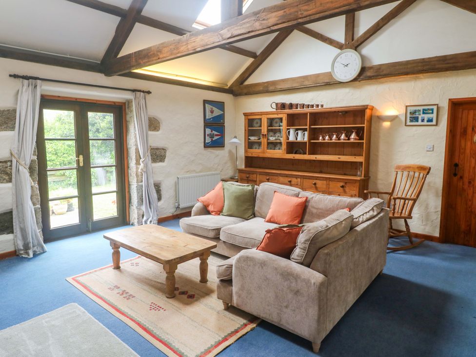 A living room with a sofa and coffee table at Swallow Cottage in Helston