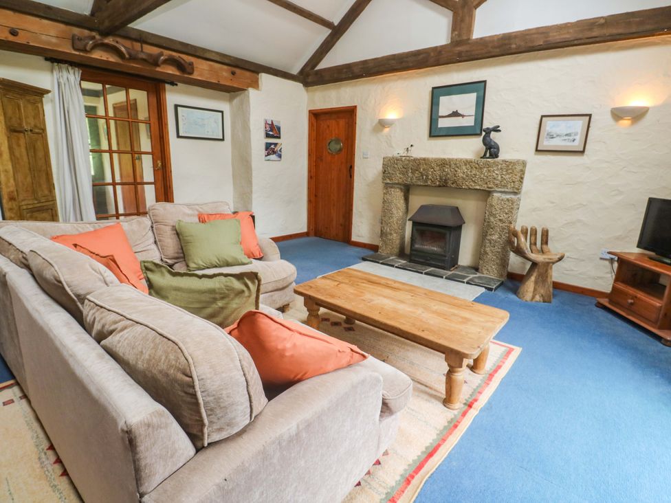 A living room with a sofa and coffee table at Swallow Cottage in Helston
