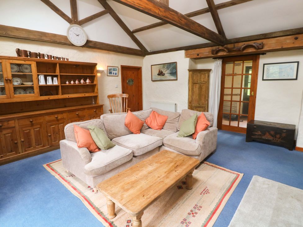 A living room with a sofa and coffee table at Swallow Cottage in Helston