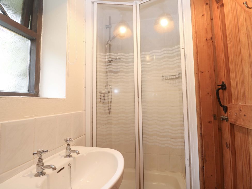 A bathroom with a shower and basin at Swallow Cottage in Helston