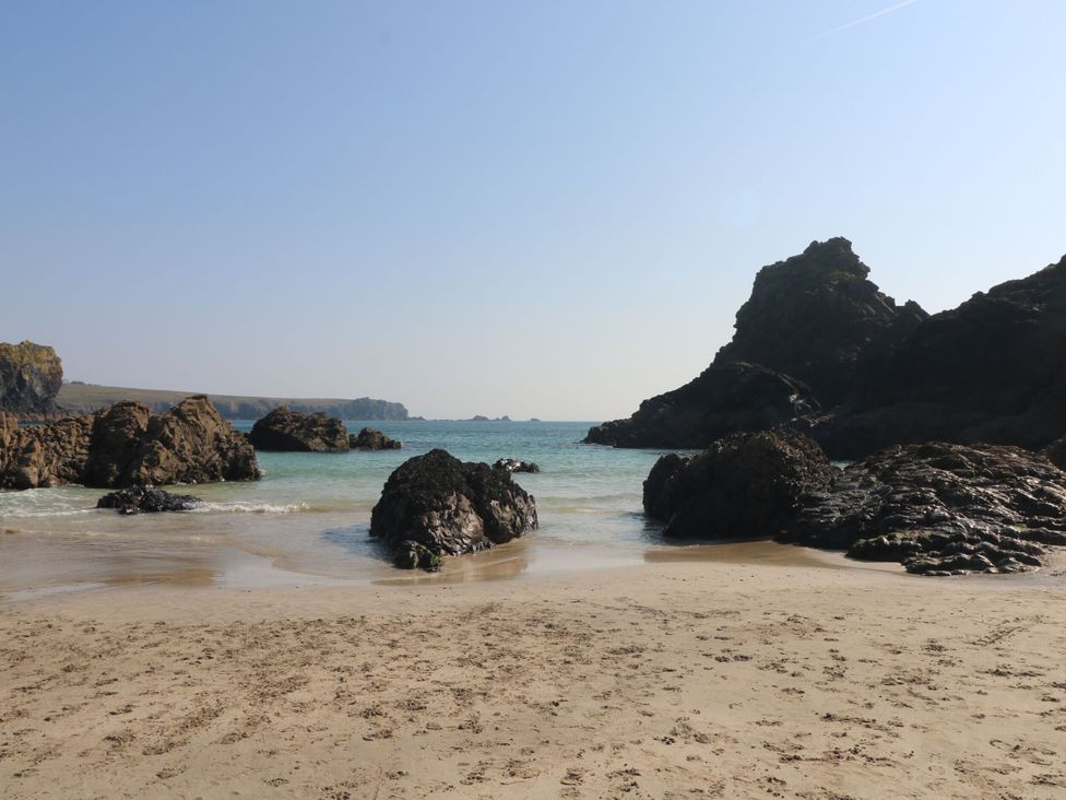 A beach view with rocks and sea at Swallow Cottage in Mullion