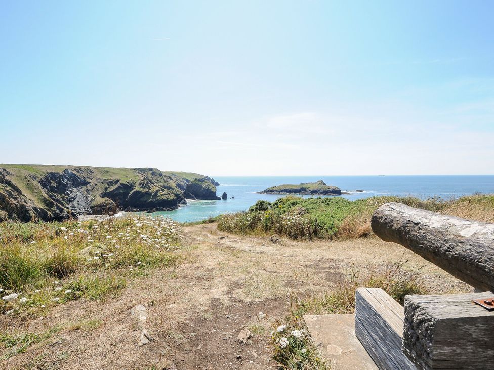 A coastal view with cliffs and ocean at Swallow Cottage in Mullion