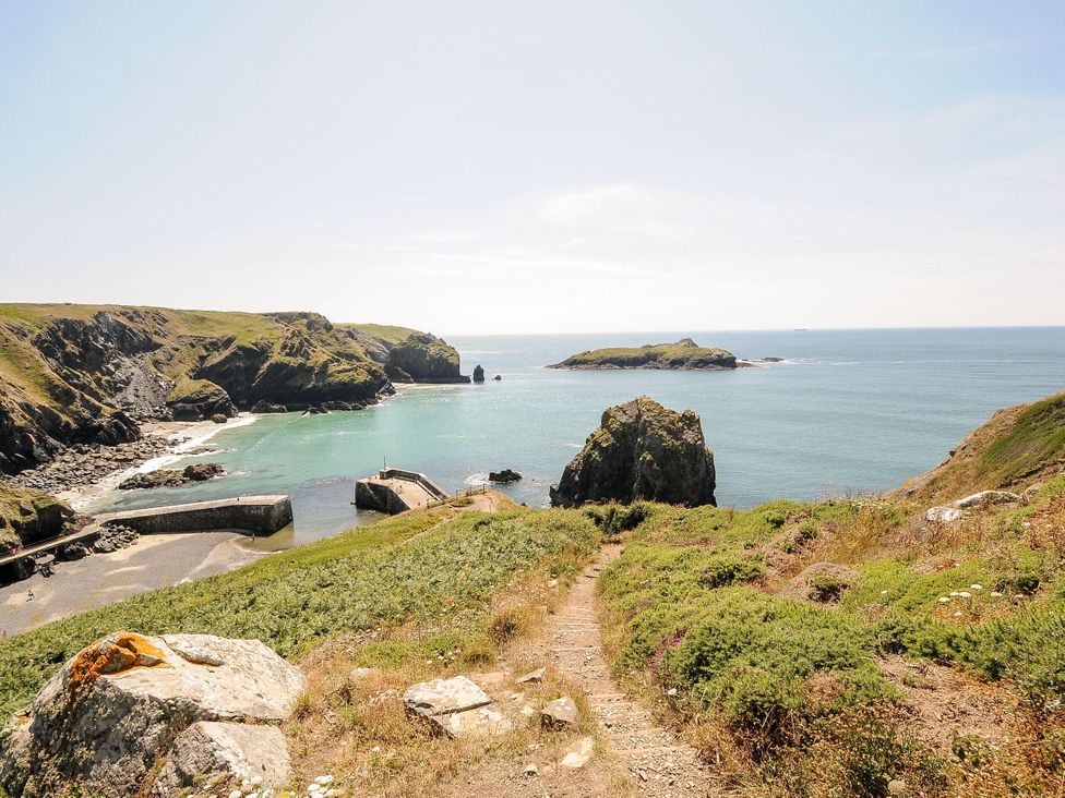 A coastal view with rocks and sea at Swallow Cottage in Mullion