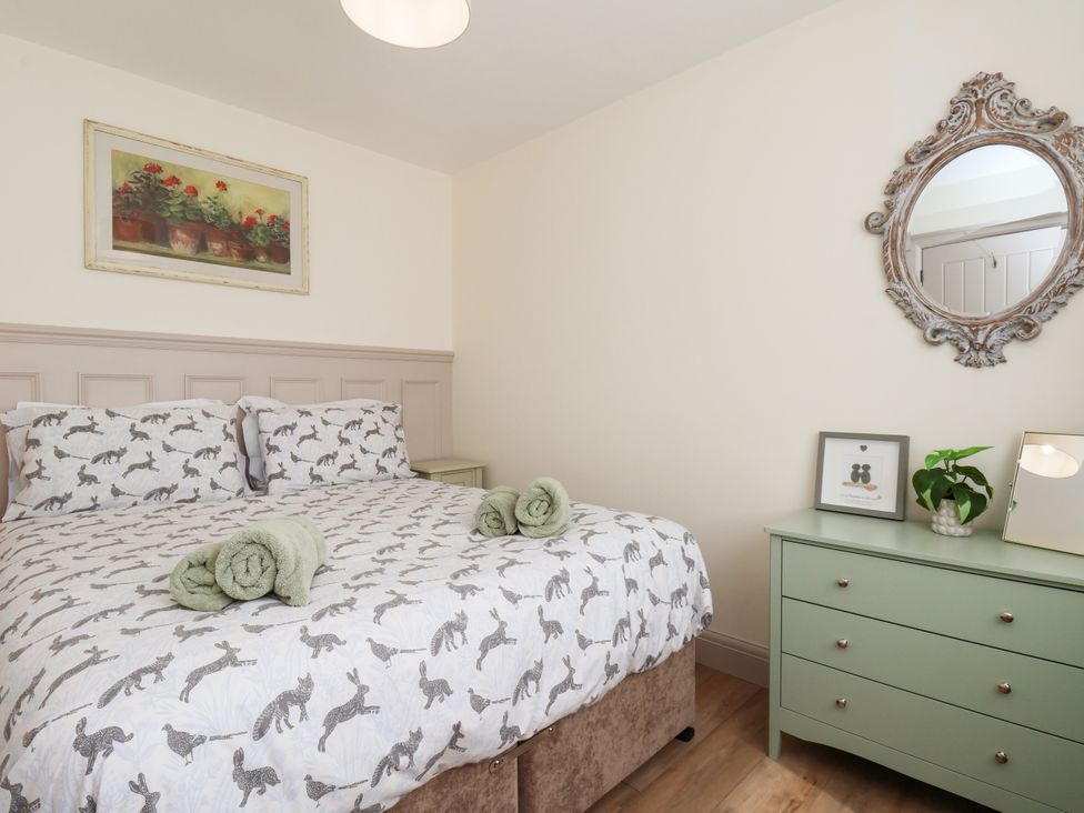A bedroom with a bed and dresser at Badger Cottage in Driffield