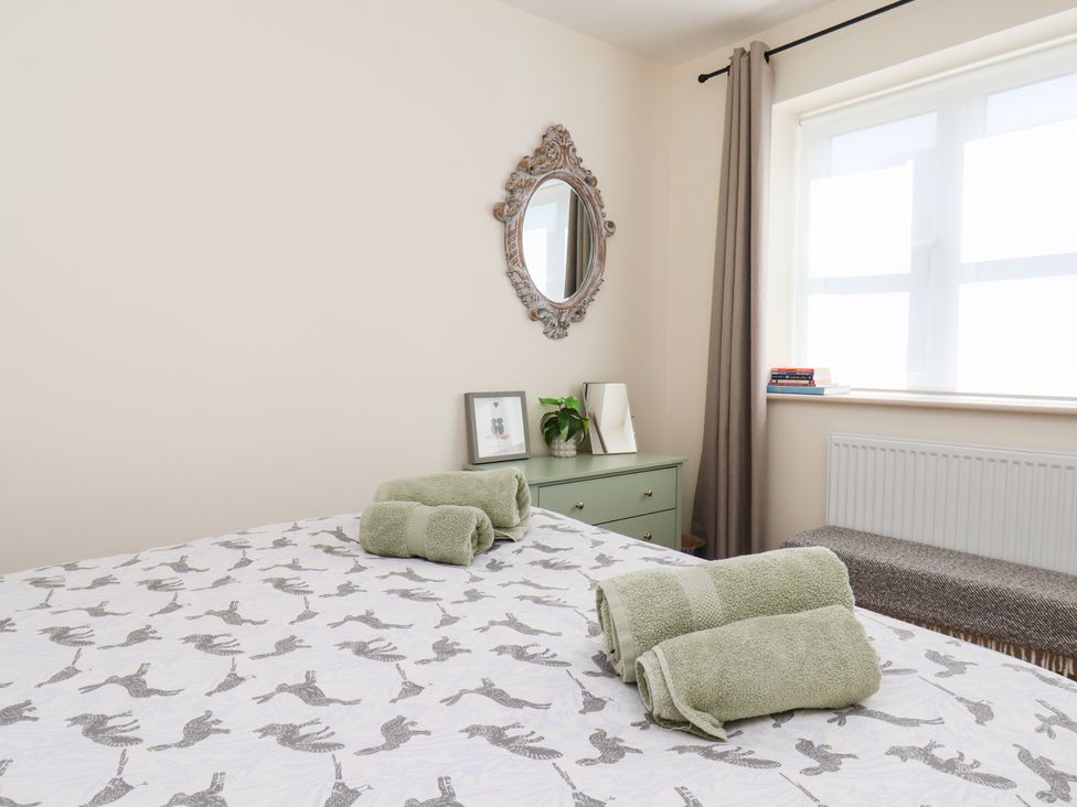 A bedroom with a bed and towels at Badger Cottage in Driffield