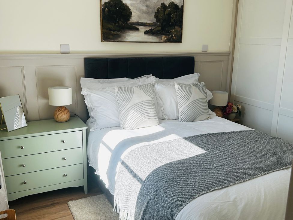 A bedroom with a bed and bedside table at Badger Cottage in Wold Newton