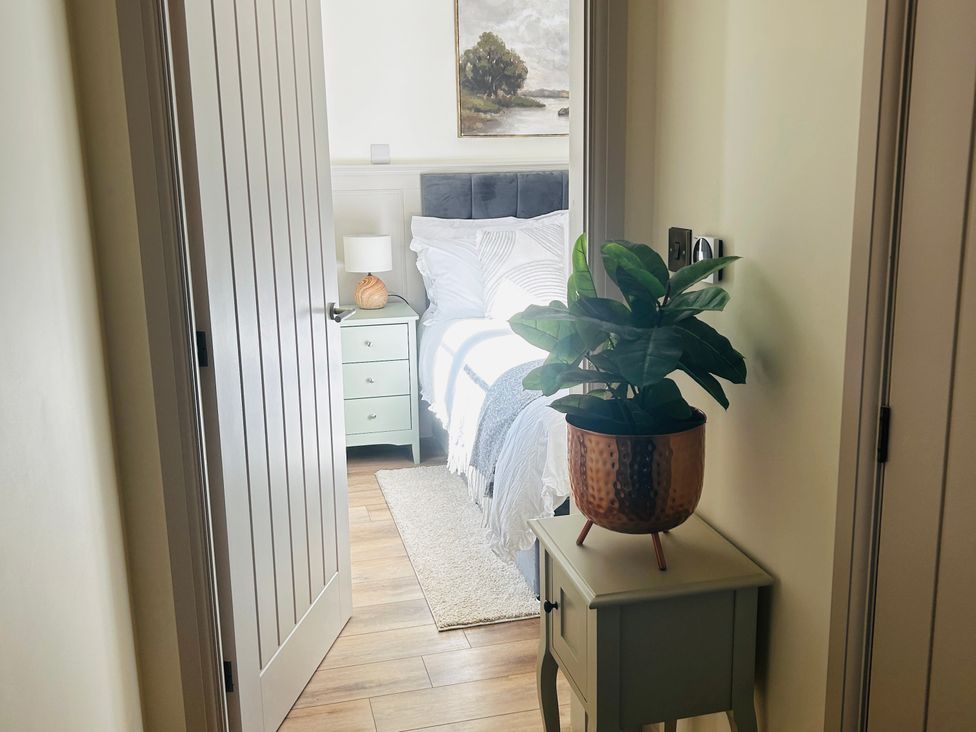 A bedroom with a bed and nightstand at Badger Cottage in Wold Newton