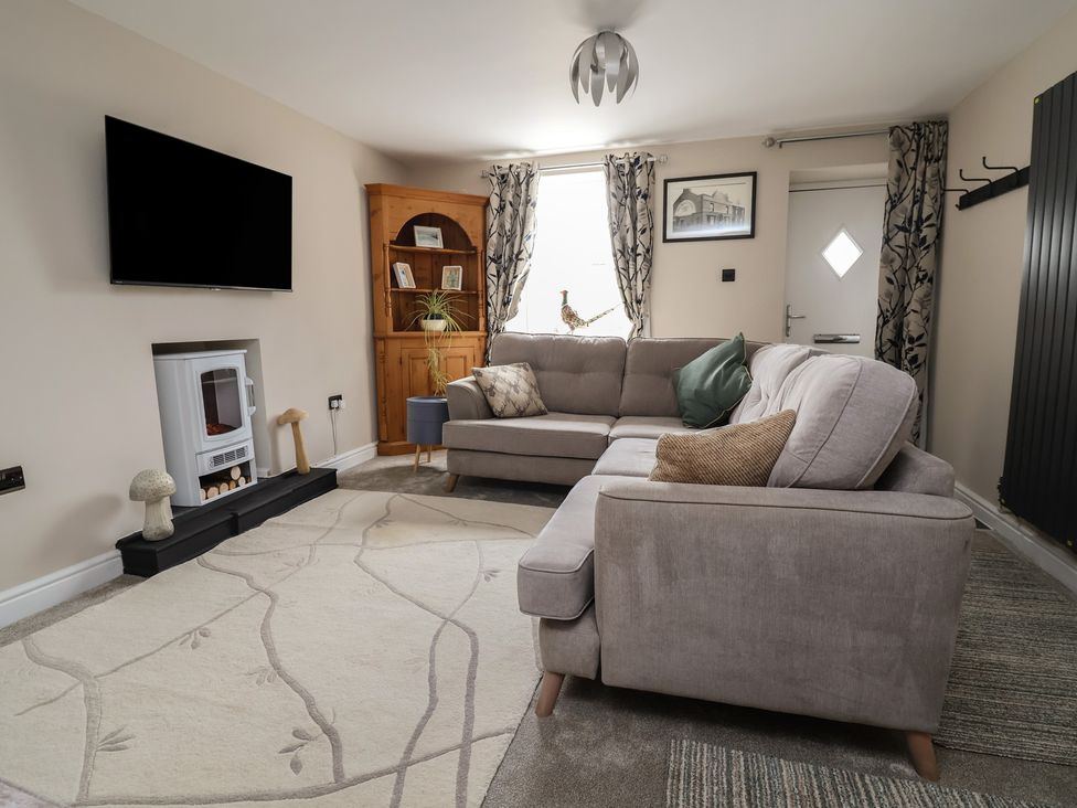 A living room with a sofa and television at The Old Shady Oak Cottage in High Peak
