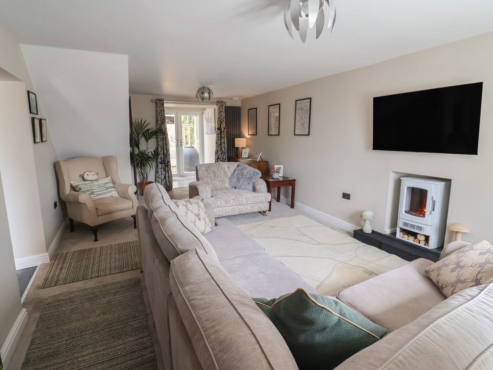 A living room with a sofa and television at The Old Shady Oak Cottage in High Peak