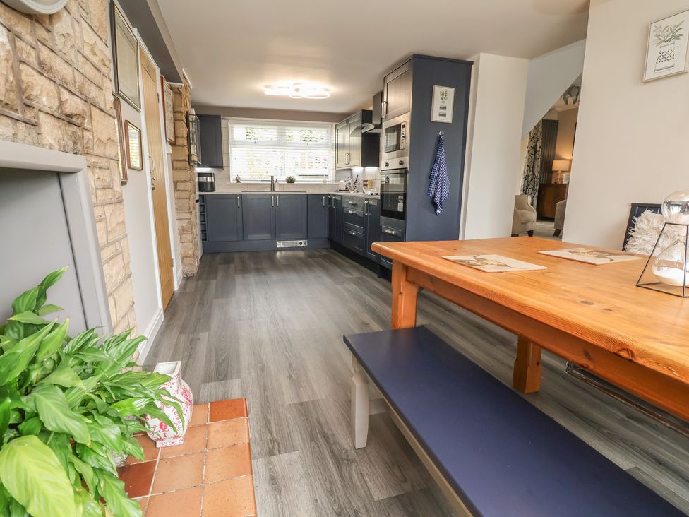 A kitchen with cabinets, dining table and appliances at The Old Shady Oak Cottage High Peak