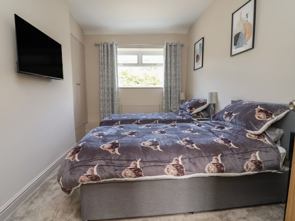A bedroom with two beds and a television at The Old Shady Oak Cottage in High Peak