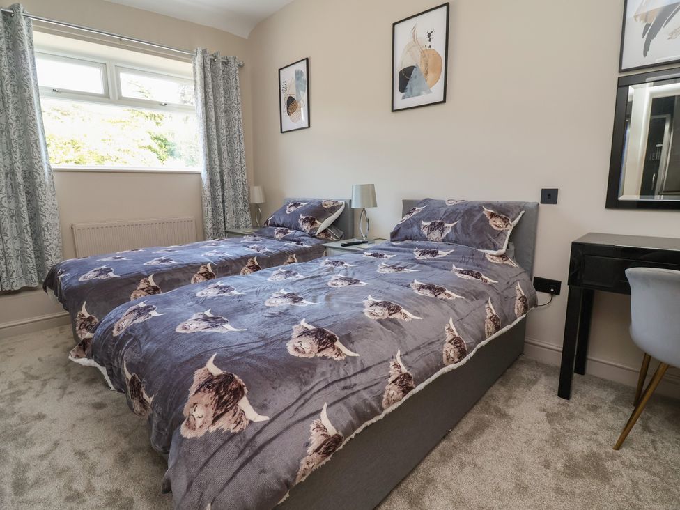 A bedroom with two beds and a table at The Old Shady Oak Cottage High Peak