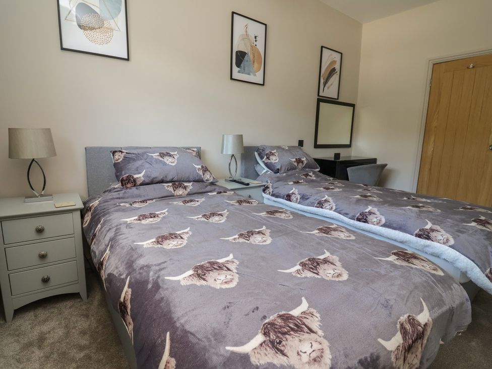 A bedroom with two beds and a desk at The Old Shady Oak Cottage in High Peak
