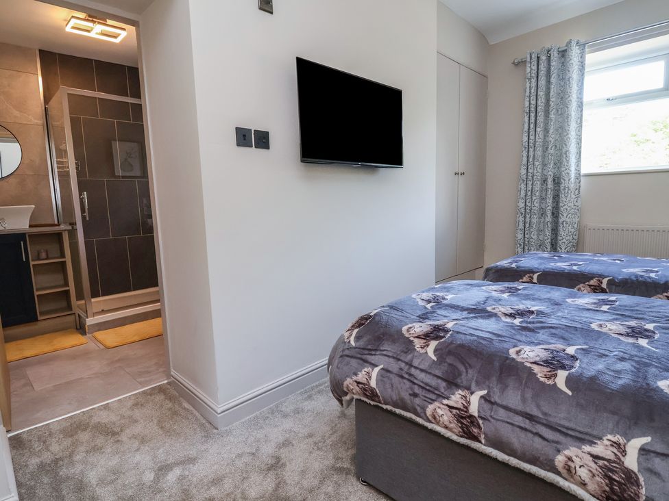 A bedroom with two beds and a television at The Old Shady Oak Cottage in High Peak