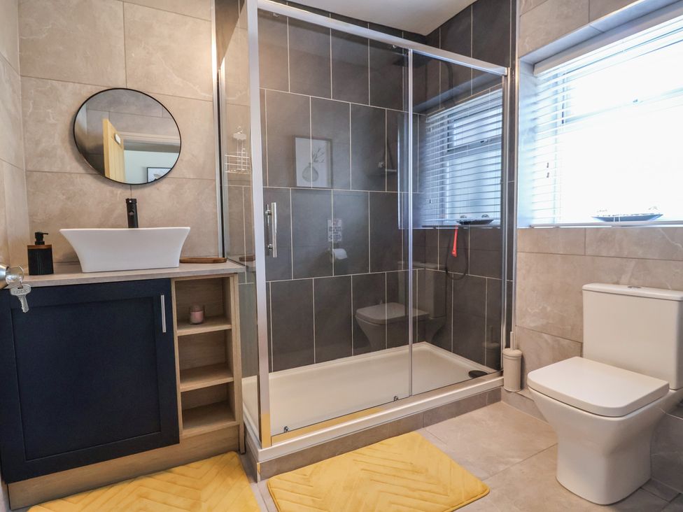 A bathroom with a shower, toilet, and vanity sink at The Old Shady Oak Cottage in High Peak