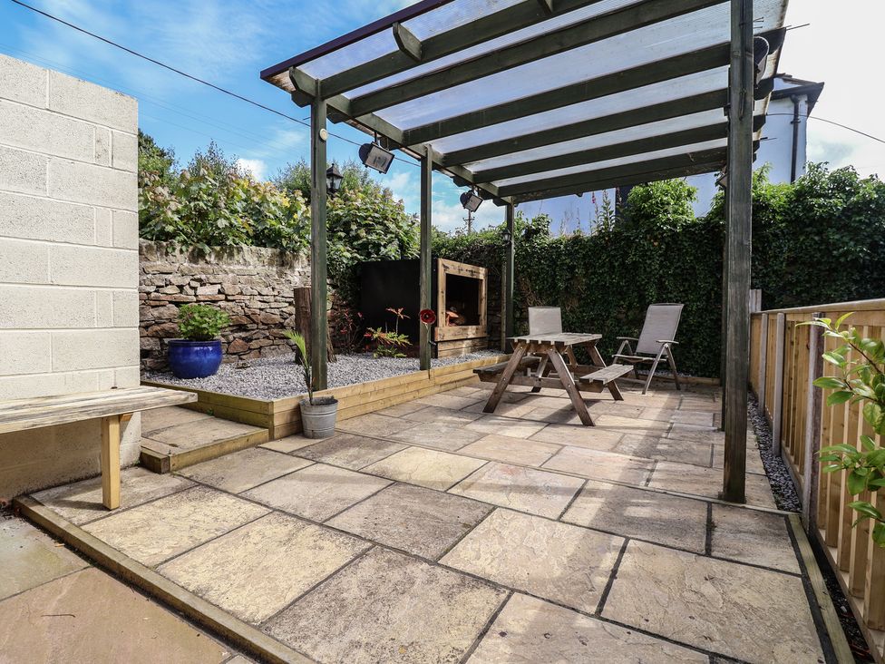 A garden with a patio and seating area at The Old Shady Oak Cottage in High Peak