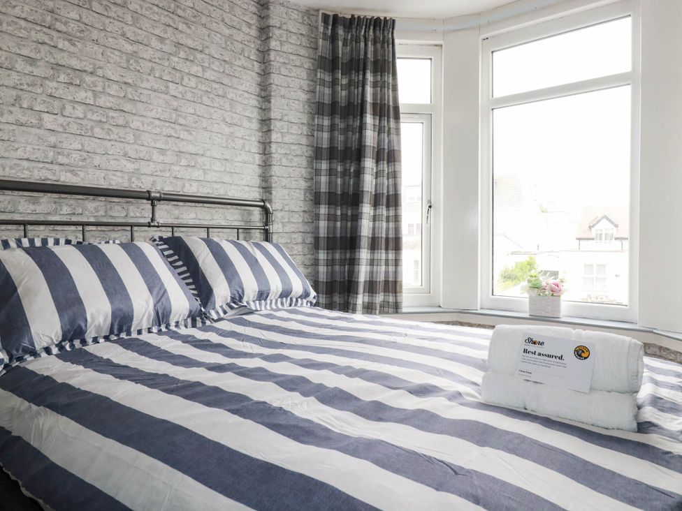 A bedroom with a bed and windows at Shoreline Studio Room No.5 in Newquay