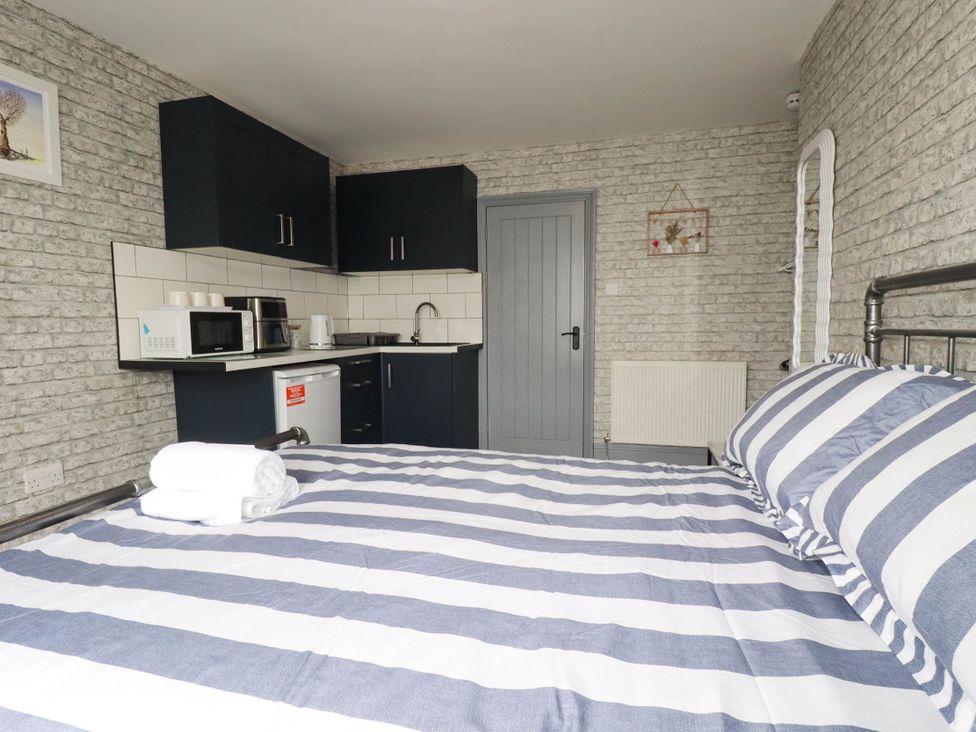 A bedroom with a kitchen area and a bed at Shoreline Studio Room No.5 Newquay