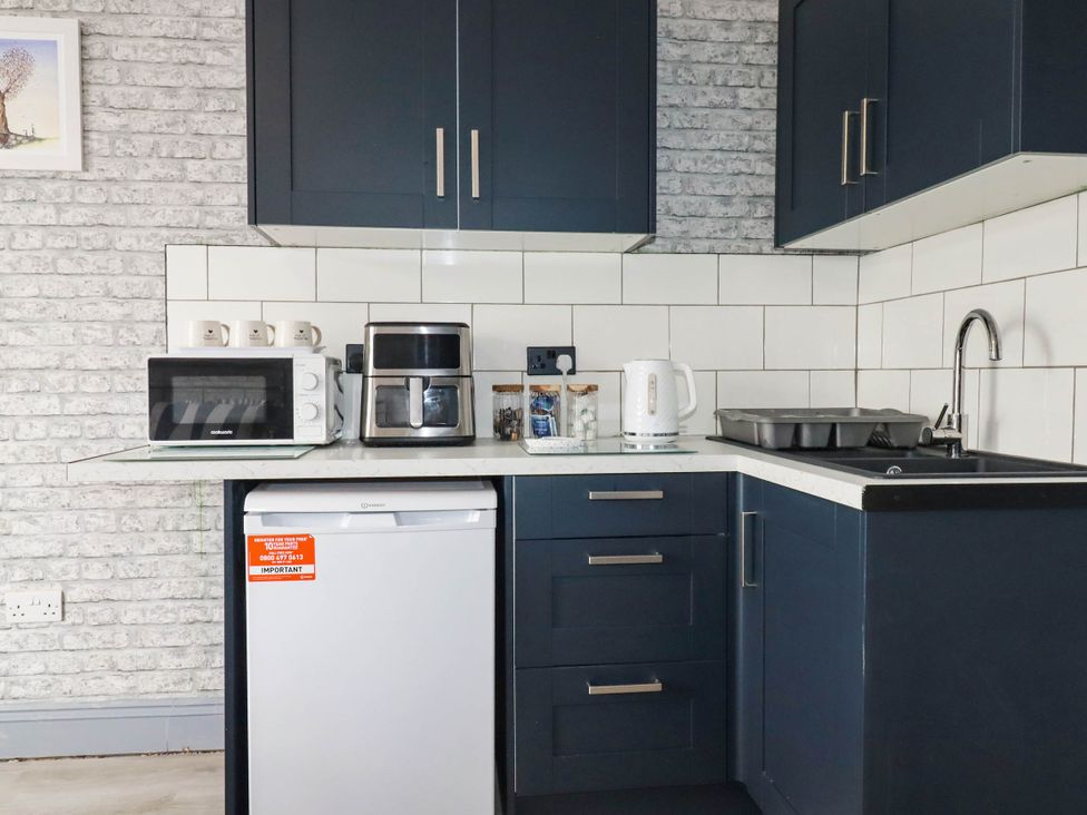 A kitchen with a microwave, kettle, and refrigerator at Shoreline Studio Room No.5 Newquay