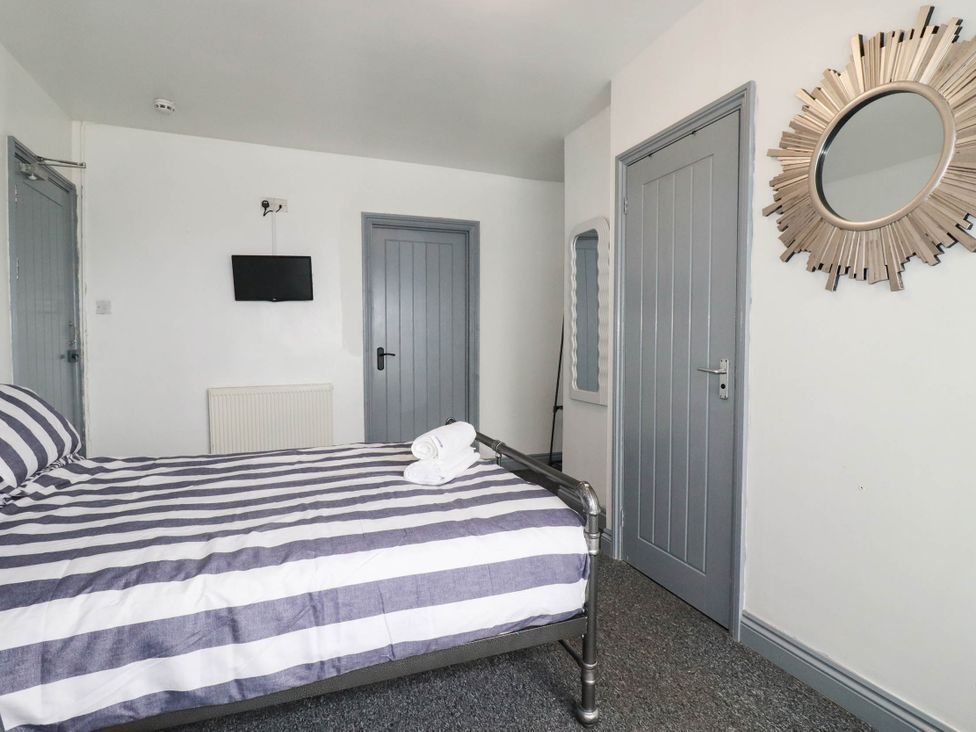 A bedroom with a bed and television at Shoreline Studio Room No.5 in Newquay