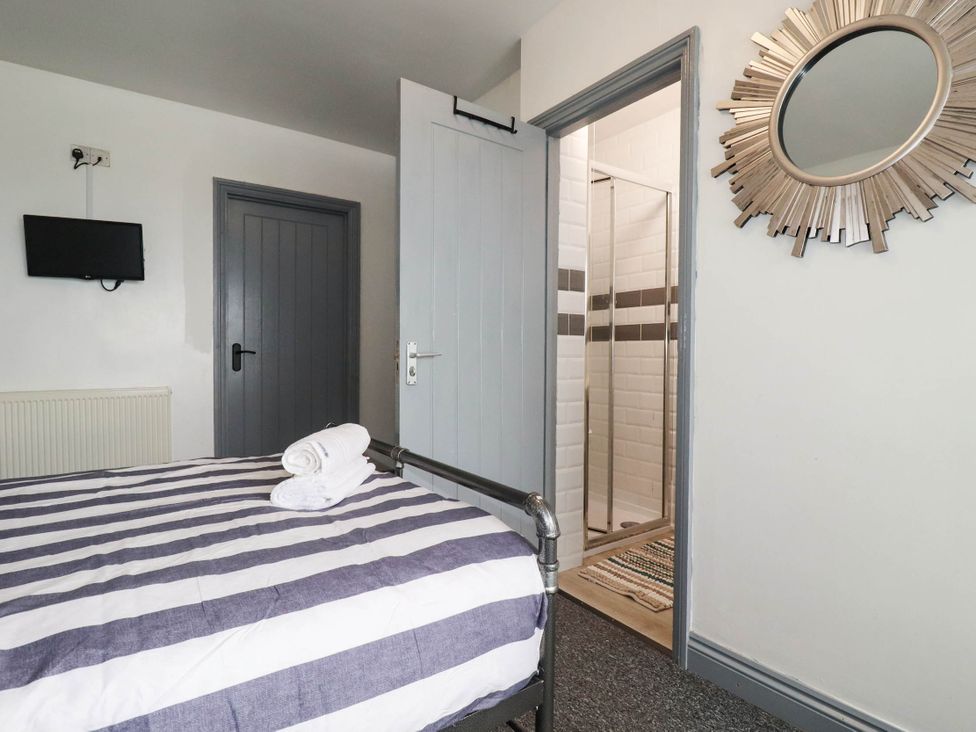 A bedroom with a bed and shower access at Shoreline Studio Room No.5 in Newquay