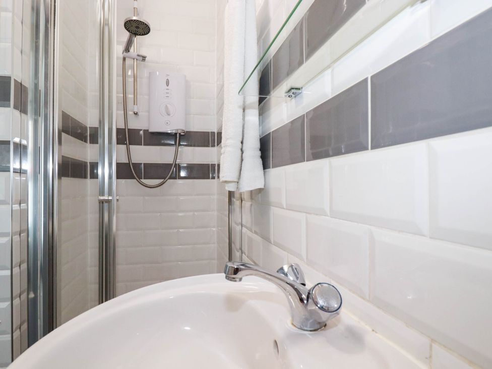 A bathroom with a shower and sink at Shoreline Studio Room No.5, Newquay