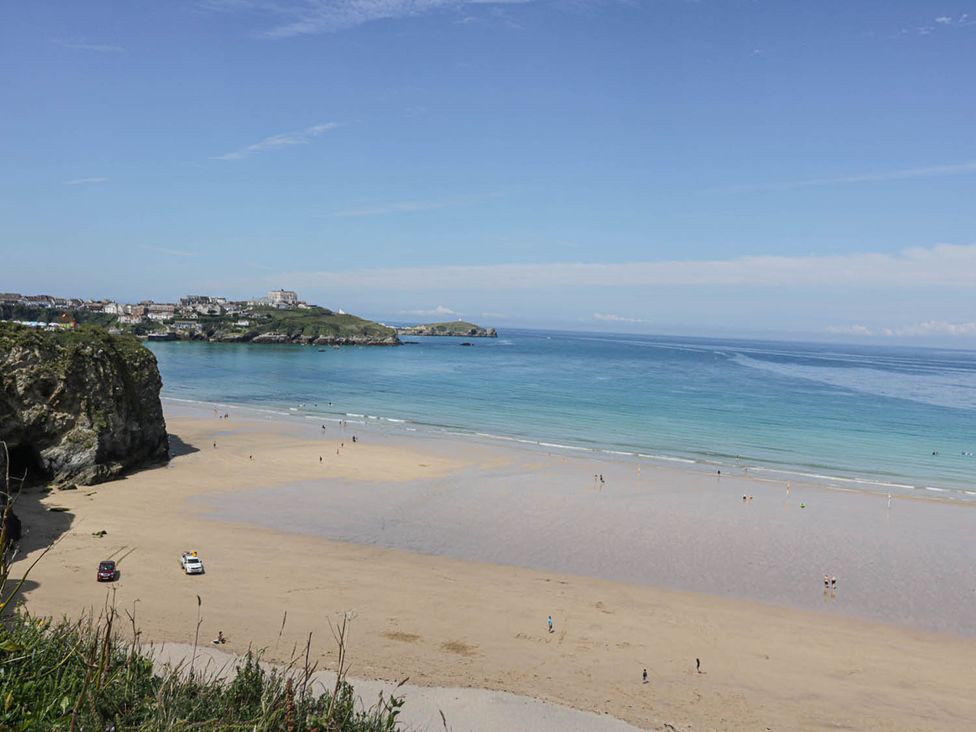 A beach with people and cars at Shoreline Studio No.7 Newquay