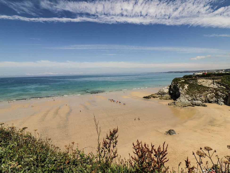 A beach with people and water at Shoreline Studio No.7 Newquay
