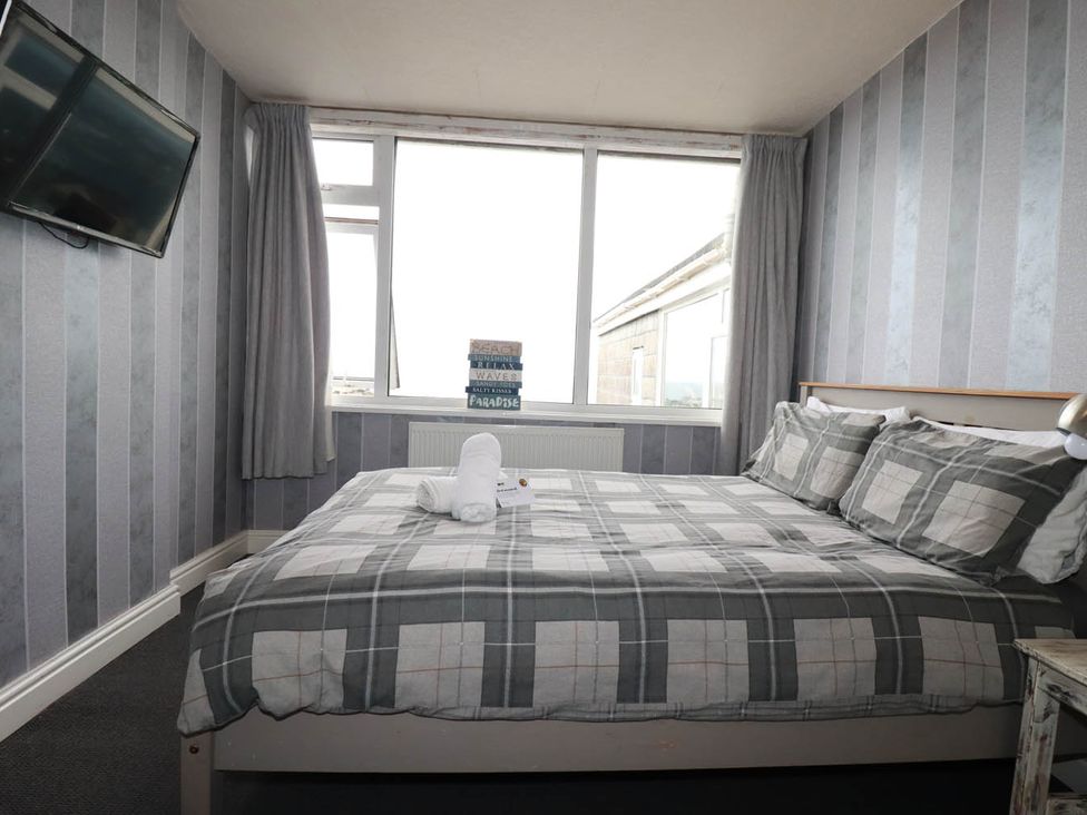 A bedroom with a bed and TV at Shoreline Studio No.7 in Newquay