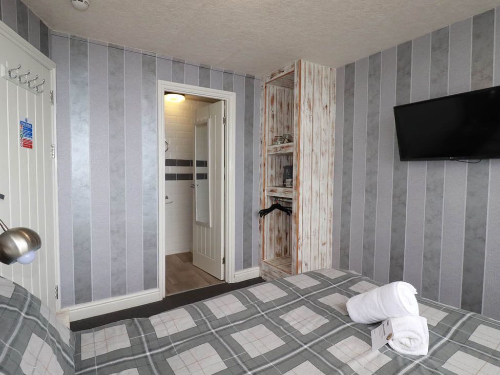 A bedroom with a bed and a TV at Shoreline Studio No.7 in Newquay