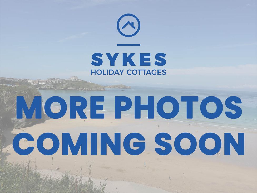 A beach view with text overlay for Sykes Holiday Cottages in Newquay